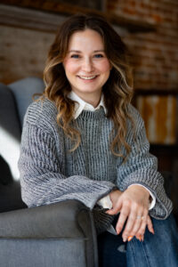 Image of Annie Griffin, a smiling young woman seated in a gray chair