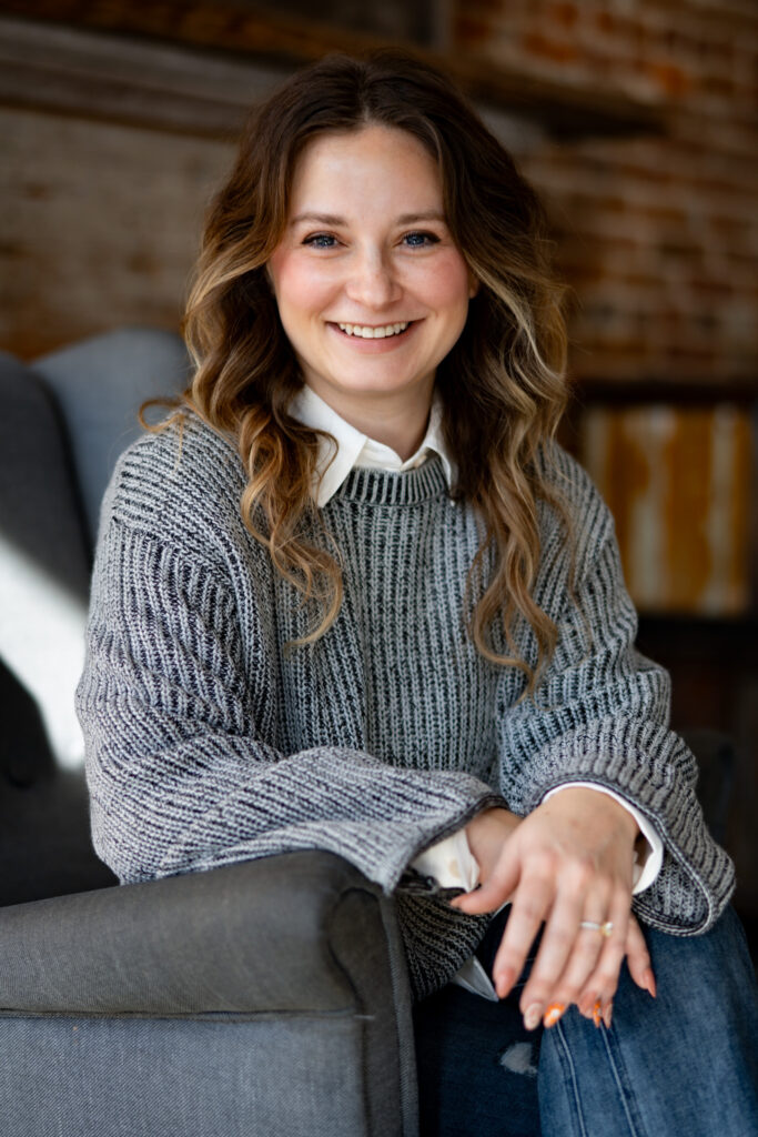 Image of Annie Griffin, a smiling young woman seated in a gray chair