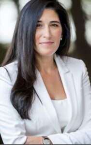Tammie Bradley standing in a white suit, looking at the camera and smiling